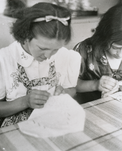 876567 Portret van twee meisjes uit een club van het Franciscus Liefdewerk die borduren in het St. Franciscushuis ...